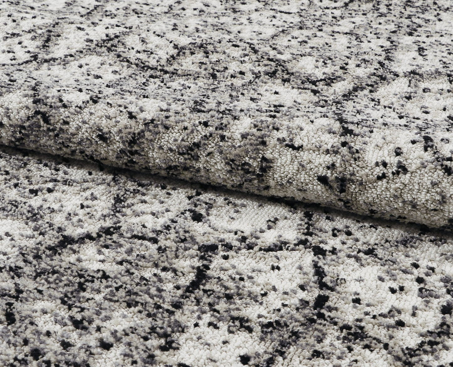 Close-up of gray and black speckled stone rug