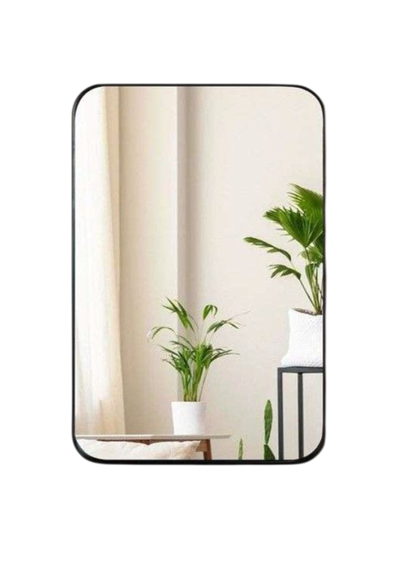 Rectangular mirror with a black frame reflecting a room with plants and furniture.