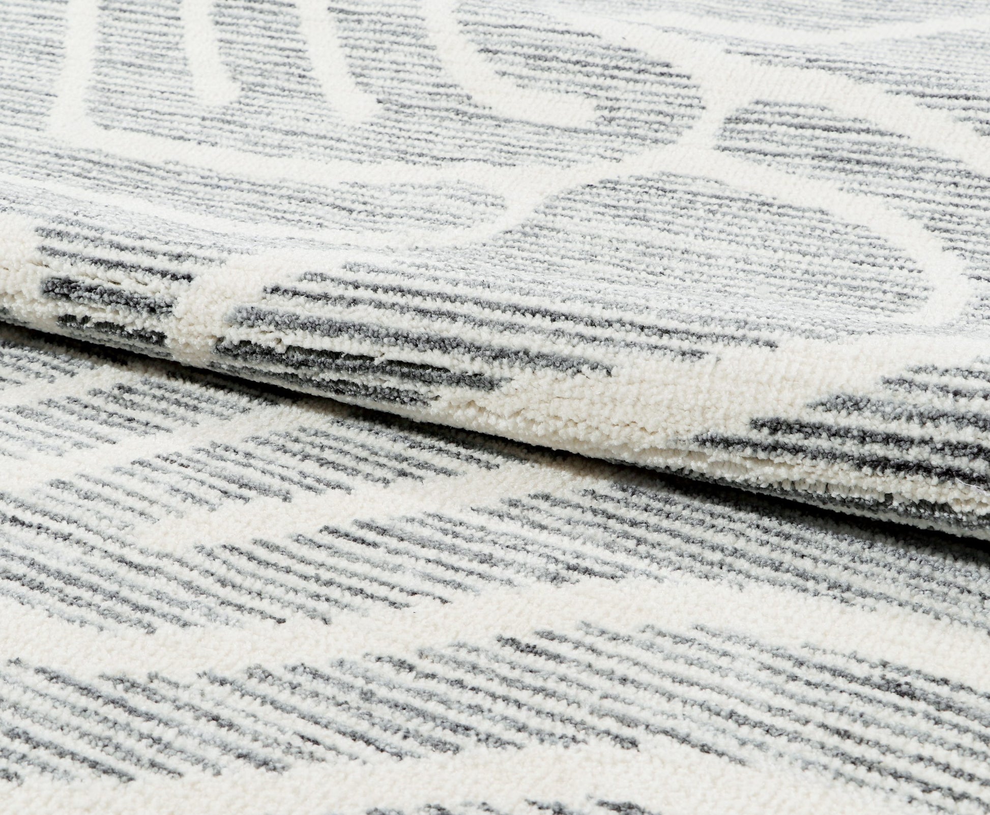 Close-up of a textured white and gray rug
