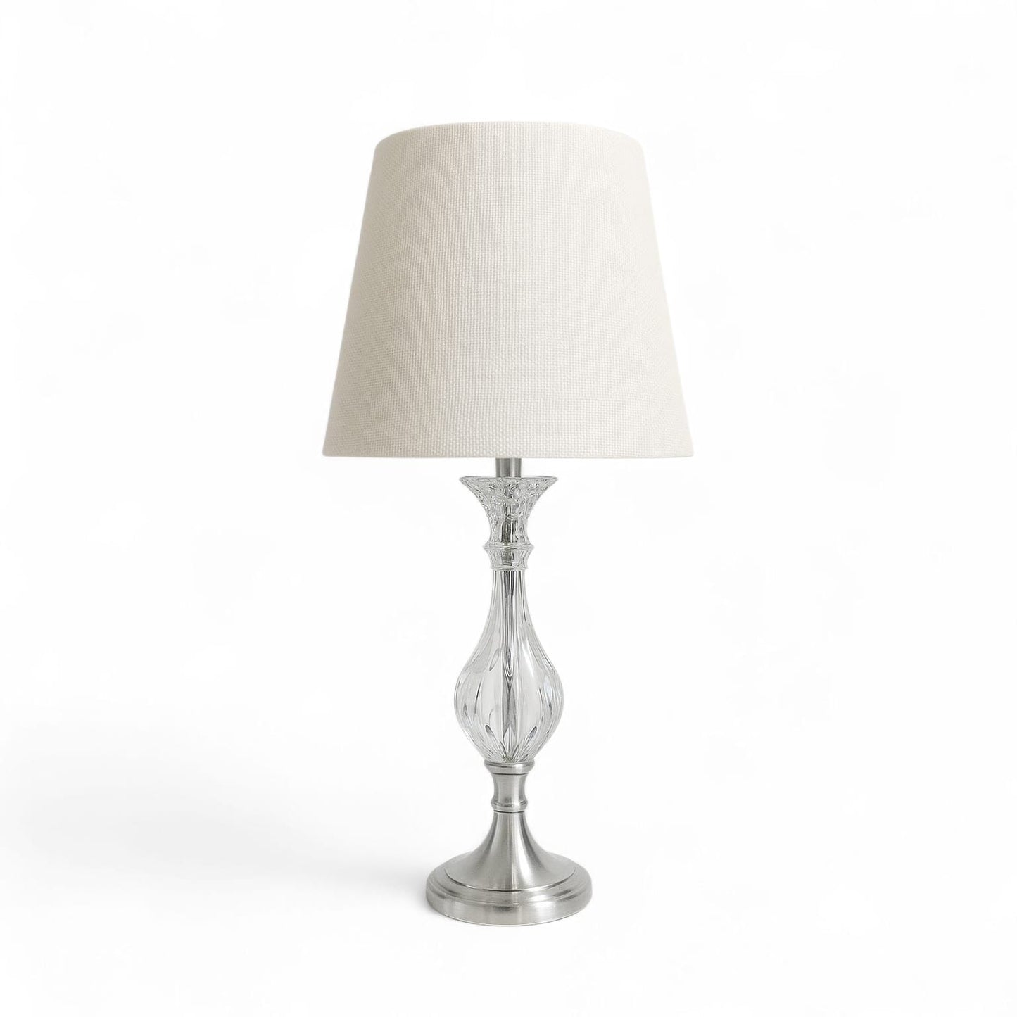 Table lamp with a white shade and silver base on a white background
