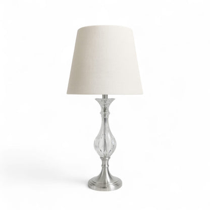 Table lamp with a white shade and silver base on a white background