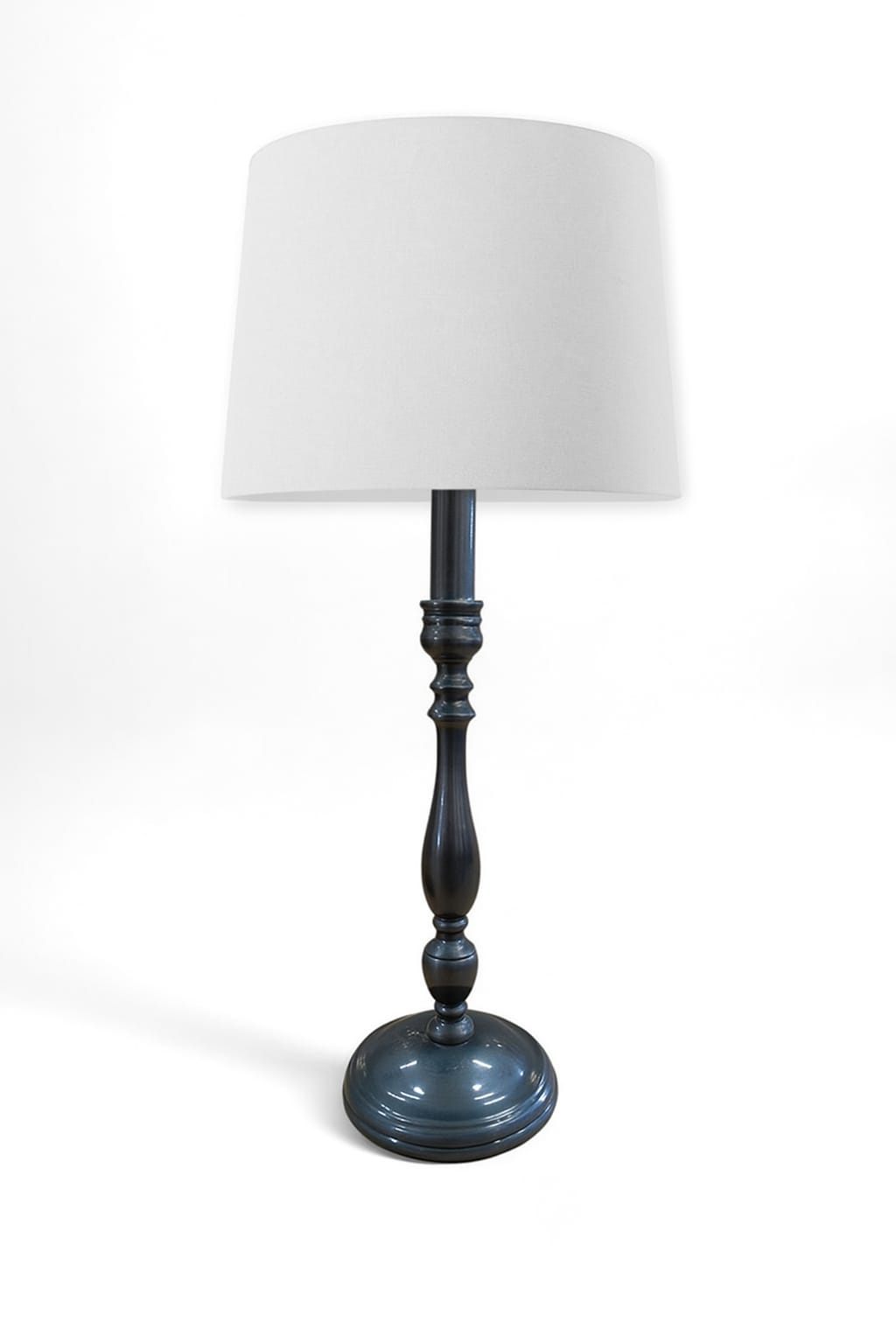 Table lamp with a white shade and dark blue base on a white background