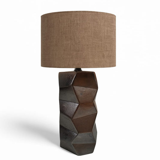 Table lamp with geometric base and brown fabric shade on a white background