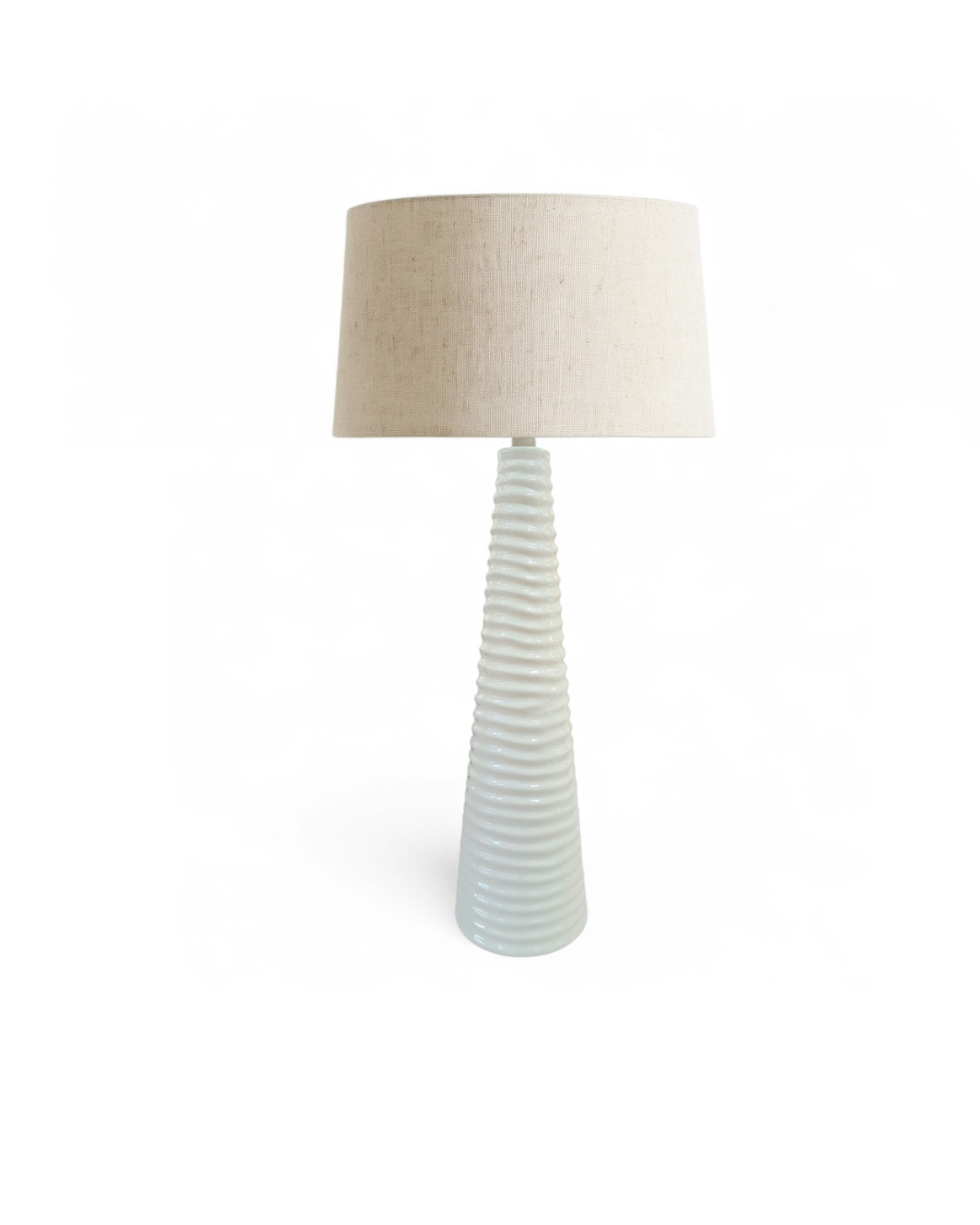 Table lamp with ribbed ceramic base and beige lampshade on a white background