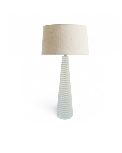 Table lamp with ribbed ceramic base and beige lampshade on a white background