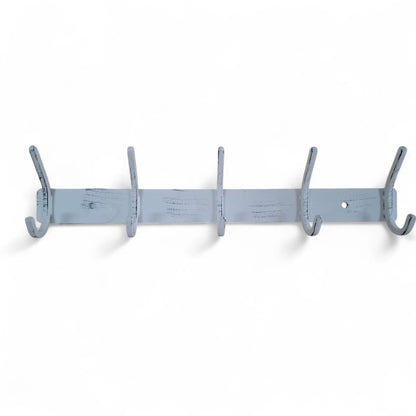 White wall-mounted coat rack with multiple hooks on a white background